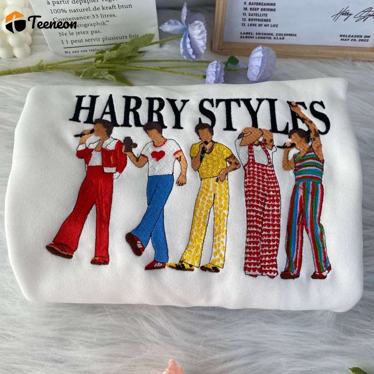 the harry styles pouch bag is decorated with three women in colorful pants and one has a name on it