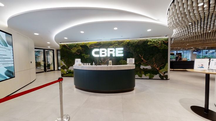 an office lobby with a curved counter and large screen