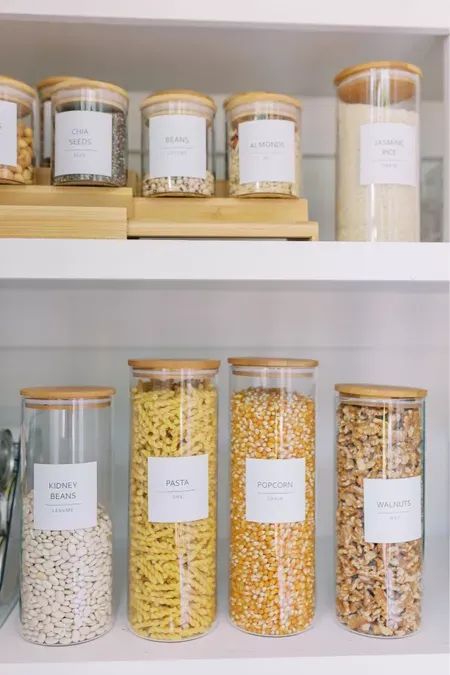 the shelves are filled with different types of cereals and other things in glass jars