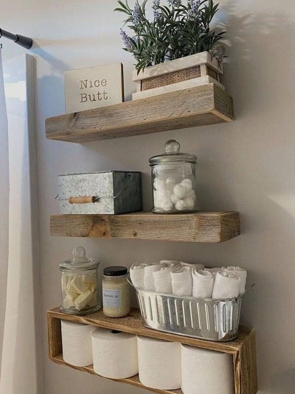 two wooden shelves holding toilet paper and other items