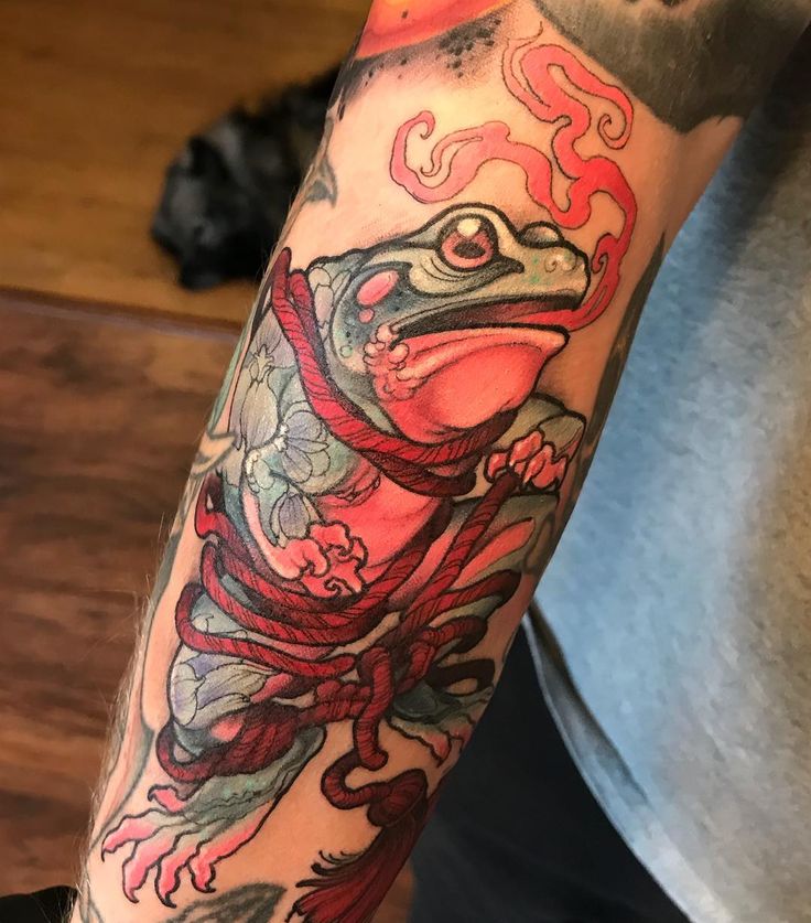 a man with a tattoo on his arm has a red snake wrapped around the neck