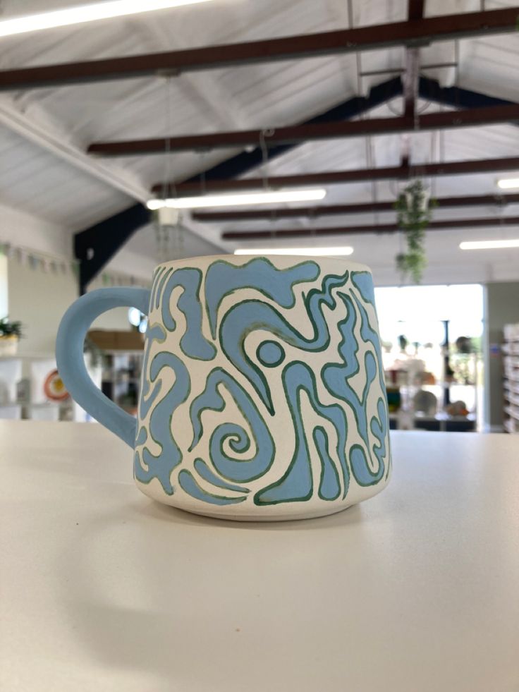 a blue and white mug sitting on top of a table