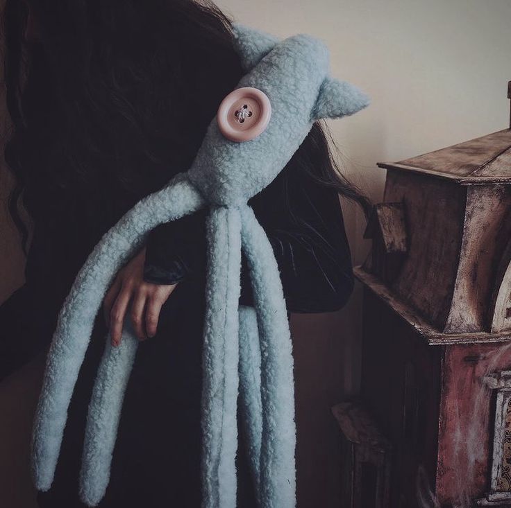 a woman wearing an octopus costume with her hair in the wind and holding onto a stuffed animal