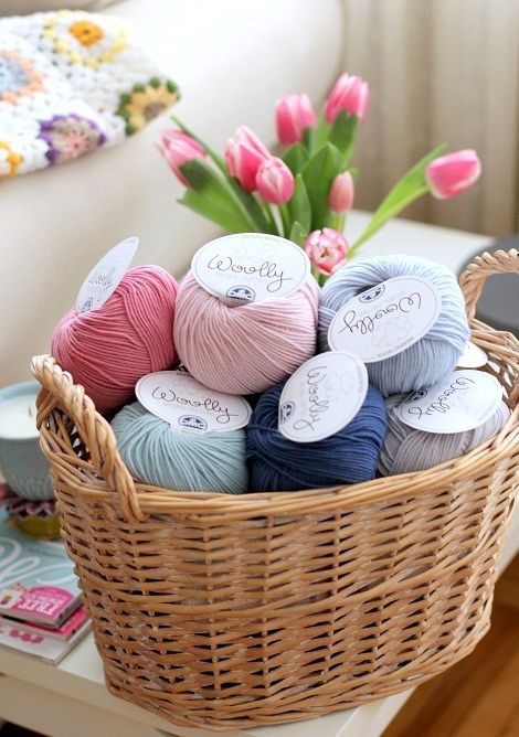 a basket filled with balls of yarn on top of a table next to a couch