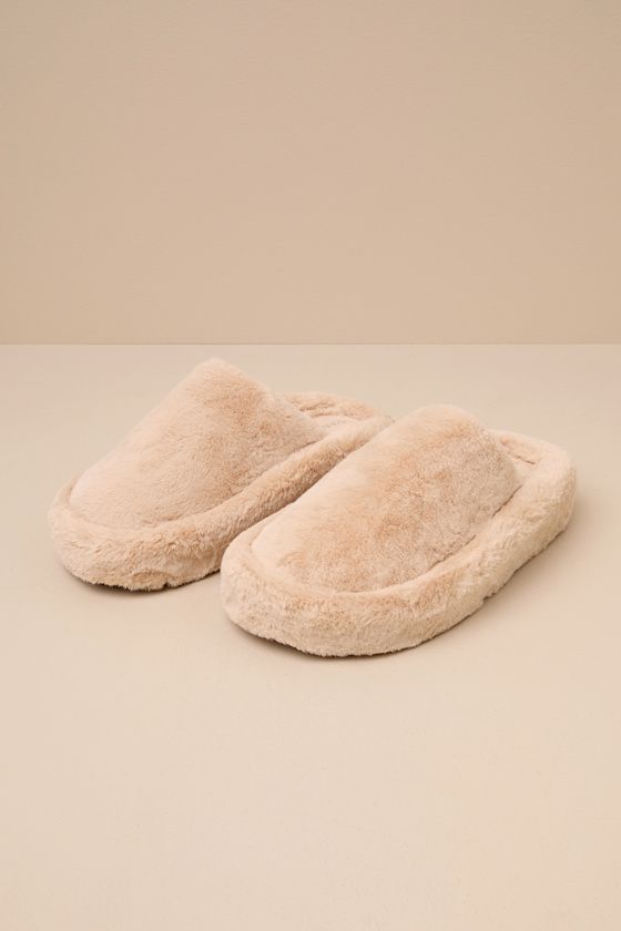 Slide through the day in maximum comfort (and style) thanks to the D'Amelio Footwear Socozee Beige Faux Fur Flatform Slippers! Super soft and fuzzy faux fur shapes the perfect slipper silhouette with a rounded toe upper and a slide-on design. Matching faux fur lines the interior for extra-cozy wear, while the chunky, flatform-inspired heel completes the look. Available in whole sizes only. 1. 75" wrapped heel. Cushioned insole. Felted rubber sole has nonskid markings. Man Made Materials. Importe Comfy Slippers With Faux Fur Lining, Winter Slippers With Faux Fur Lining For Loungewear, Winter Faux Fur Lined Slippers For Loungewear, Comfy Fluffy Slippers For Loungewear, Fluffy Comfy Slippers For Loungewear, Winter Loungewear Slippers With Faux Fur Lining, Fluffy Round Toe Slippers For Loungewear, Comfortable Cozy Slippers With Faux Fur Lining, Cozy Slippers With Faux Fur Lining