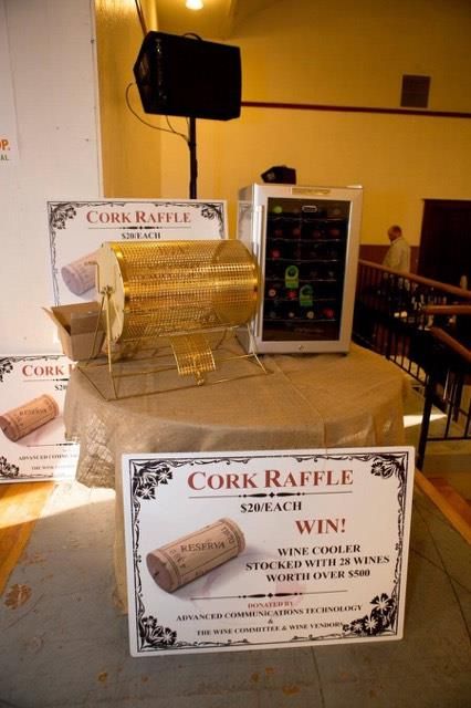 there is a table with wine bottles on it and a sign that says cork raffle