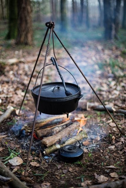 a pot is sitting on top of a campfire in the woods