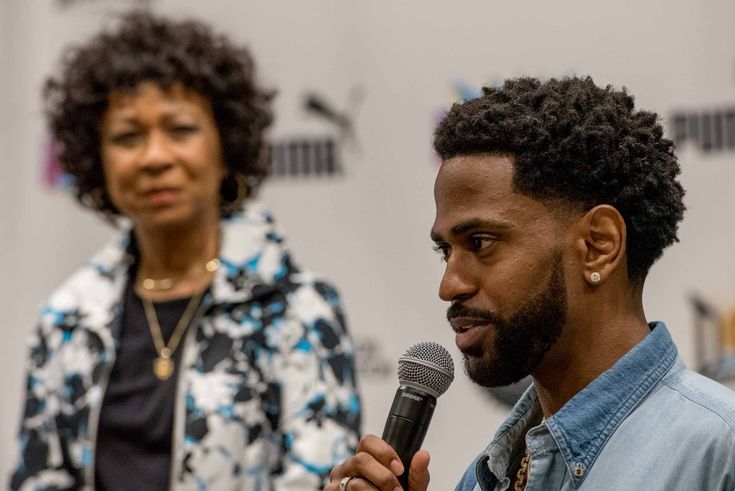 a man holding a microphone while standing next to a woman