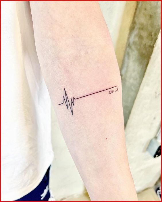 a woman's arm with a heartbeat tattoo on it