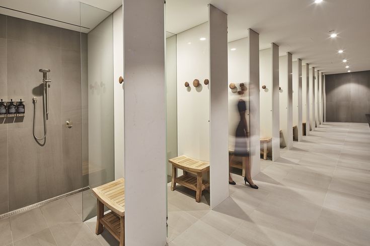 a woman is standing in the middle of an empty bathroom