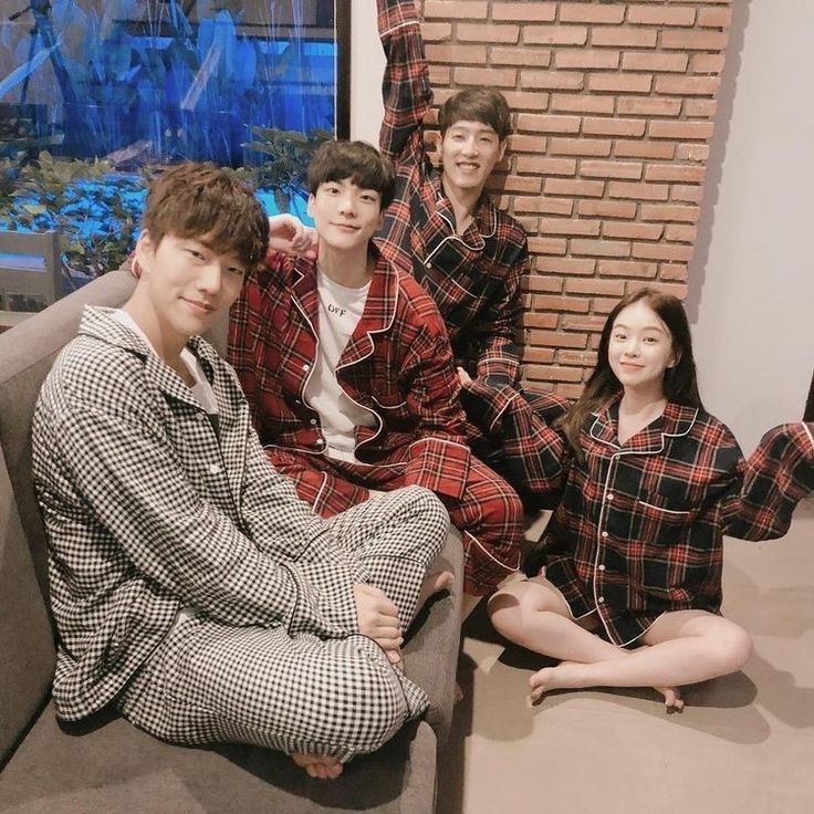 four people in matching pajamas sitting on a couch