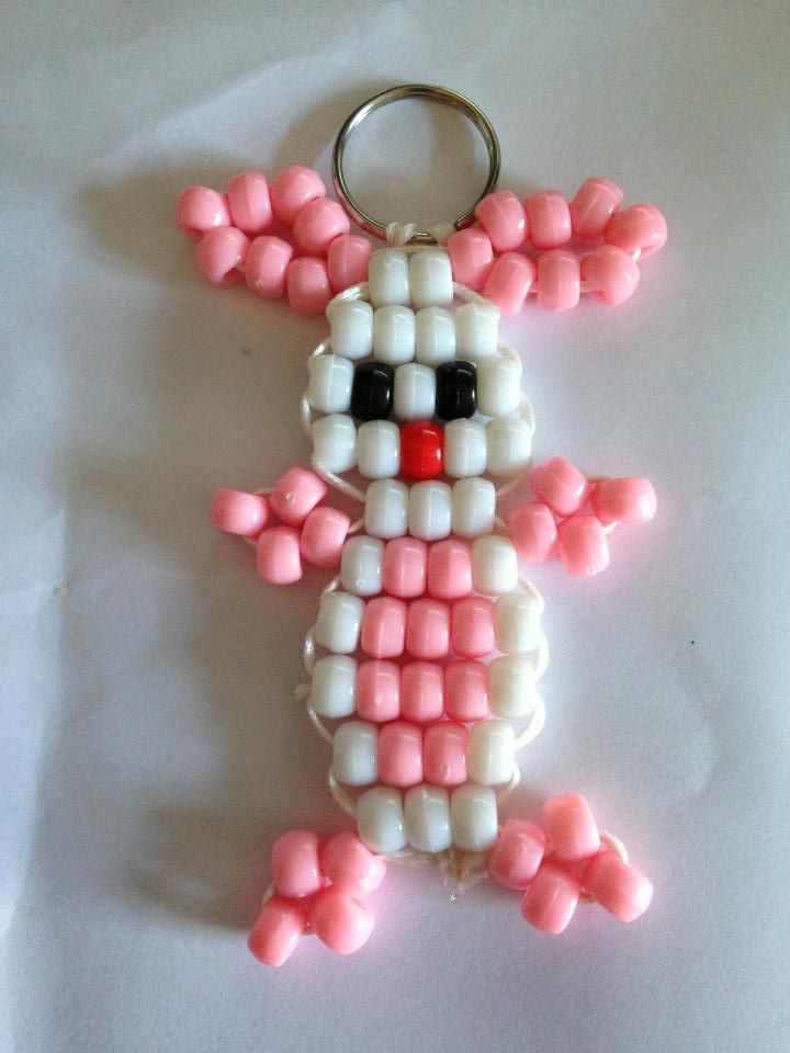 a pink and white beaded bunny keychain sitting on top of a table