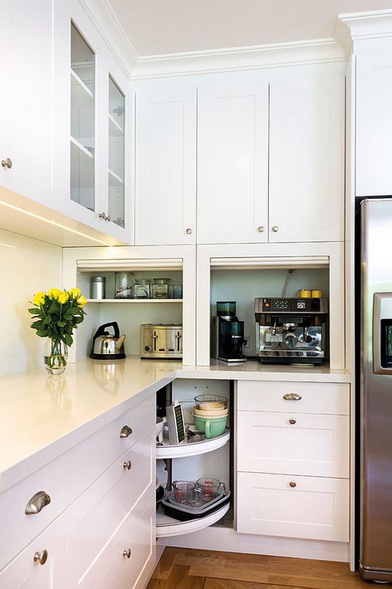 a kitchen with white cupboards and an open door on the side that has a coffee maker in it