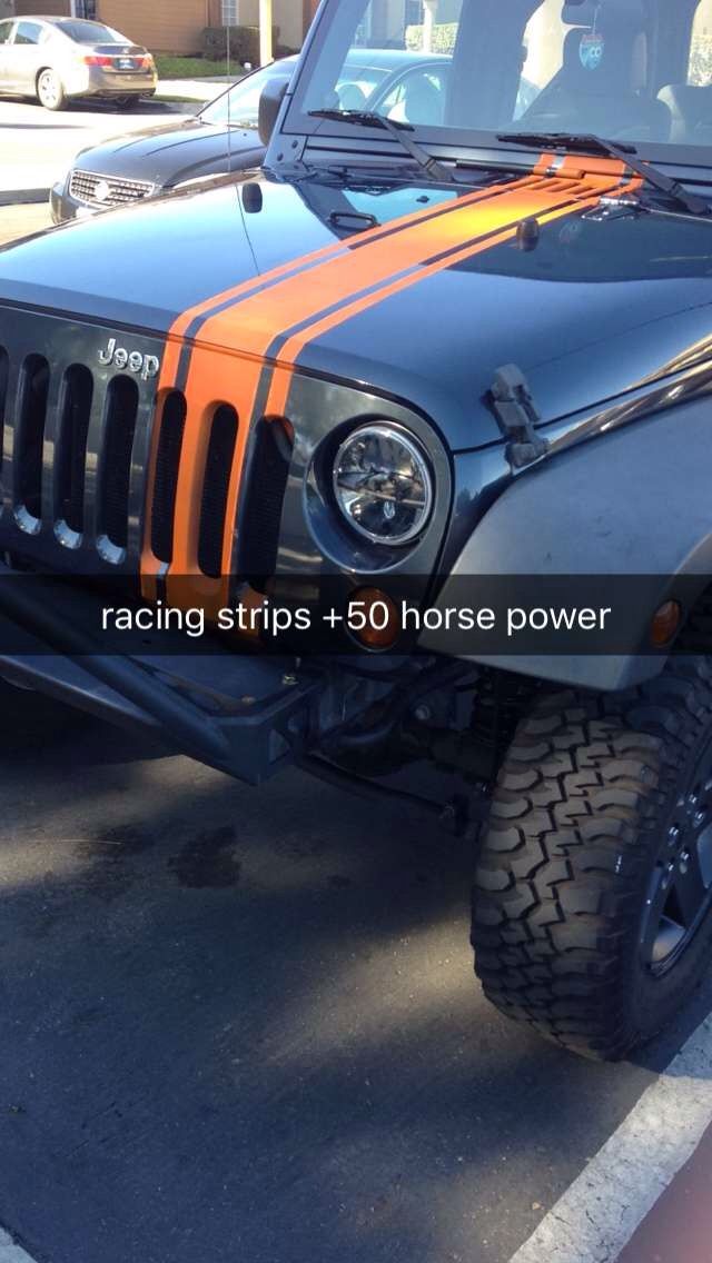 an orange and black jeep parked in a parking lot