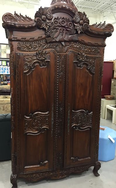 an ornate wooden armoire in a store