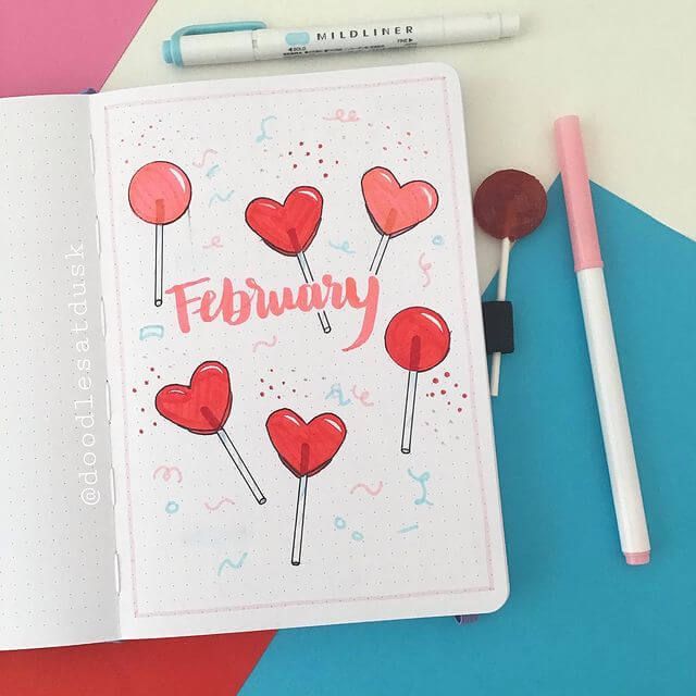 an open notebook with red hearts and the word february written on it next to some markers