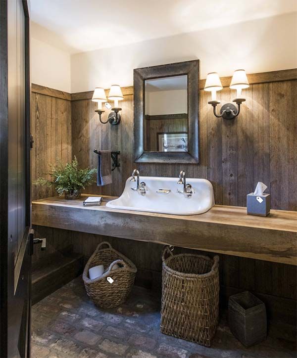 a bathroom with wood paneling and a white sink under a mirror next to two wicker baskets