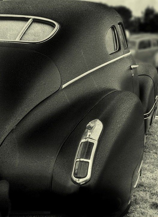 black and white photograph of an old car with the door handle down on it's side