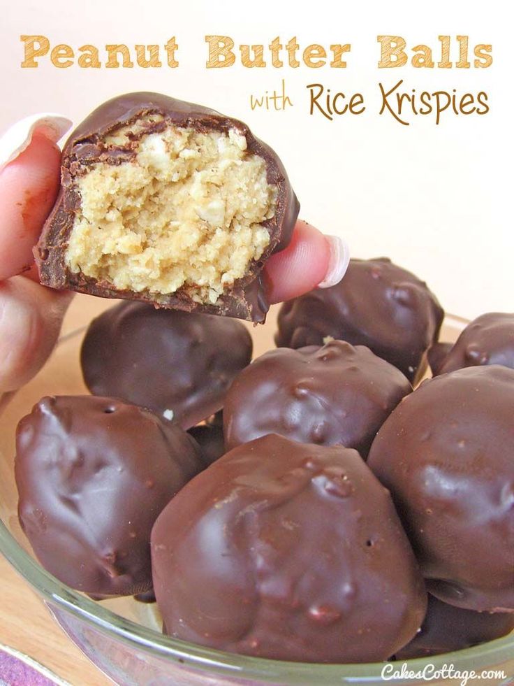 a person holding up a chocolate peanut butter ball with rice krispies