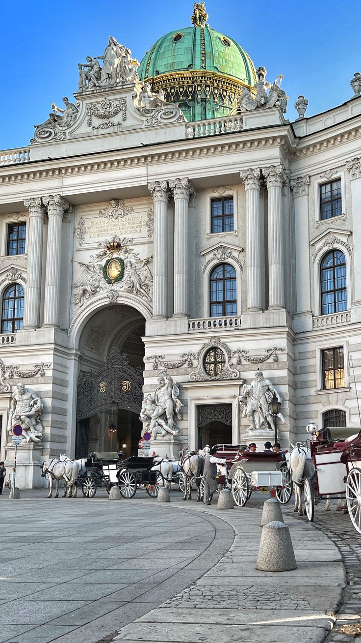 an ornate building with horses and carriages in front