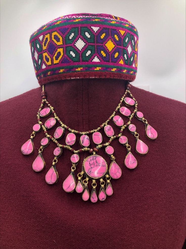 The pink stone necklace has three-layers which flaunting all the classic vibes. It is delicately crafted in a basic tribal style, whilst retaining the best stability of ethnic and modish touch. The beautiful necklace has wooden and metallic beads, assembled inside every string of the necklace alongside with a dangling pendant in the middle, complementing the tribal fashion of the ornament. The necklace is made with great metallic alloy, plated with golden rustic hues. Pair this amazing piece wit Pink Stone Necklace, Afghan Jewelry, Bib Necklaces, Layered Necklace, Bib Necklace, Pink Stone, Beautiful Necklace, Necklace Handmade, Beaded Chain