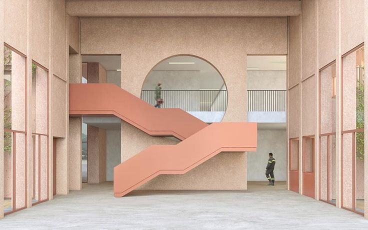 an empty building with stairs leading up to the second floor and two people standing on the other side