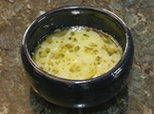 a black bowl filled with yellow liquid on top of a counter