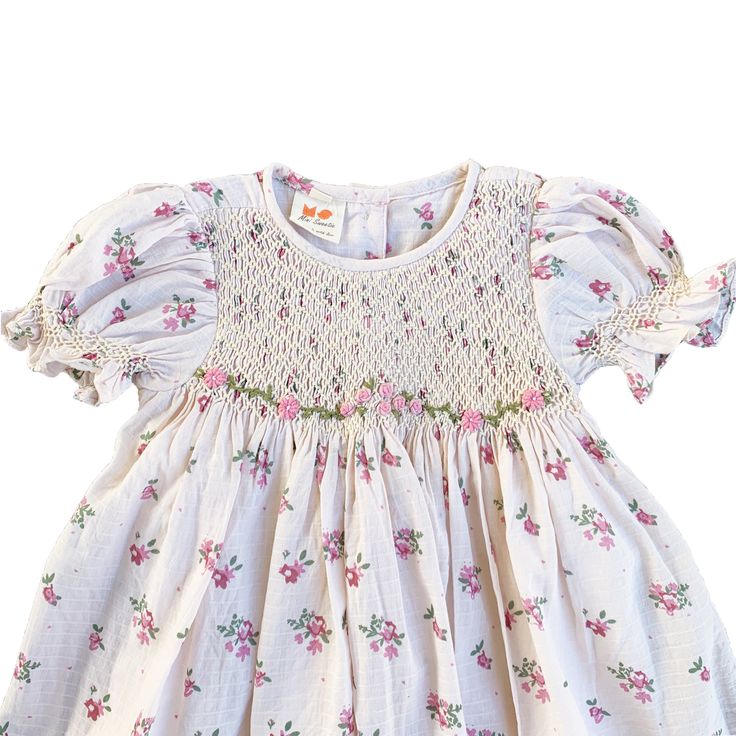 This lovely dress features a cream-colored fabric adorned with delicate pink and purple flowers. The smocked detailing adds a charming touch to the overall design, making it a perfect choice for a stylish and elegant look.  * 100% Cotton * 2 layers * Handmade * Tie at the back * Lightweight, soft cotton, comfortable * Hand wash or machine wash on a delicate setting We are based in Sydney, New South Wales, Australia. Within Australia, Standard shipping is $7 flat rate via AusPost. There is option Floral Dress With Smocked Bodice For Garden Party, Spring Cotton Smocked Dress With Ruffles, Spring Floral Print Smocked Dress With Short Sleeves, Spring Smocked Dress With Short Sleeves And Floral Print, Cotton Smocked Dress For Garden Party With Short Sleeves, Short Sleeve Smocked Dress With Floral Print For Spring, Fitted Cotton Smocked Dress With Ditsy Floral Print, Short Sleeve Smocked Dress With Floral Print, Pink Smocked Dress With Puff Sleeves For Garden Party