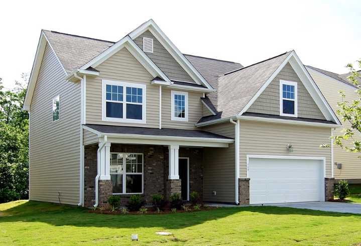 a large house with two garages in the front yard