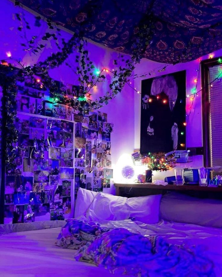 a bedroom with purple lighting and decorations on the ceiling