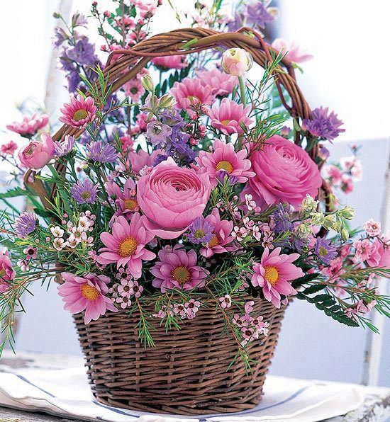 a basket filled with lots of flowers sitting on top of a table