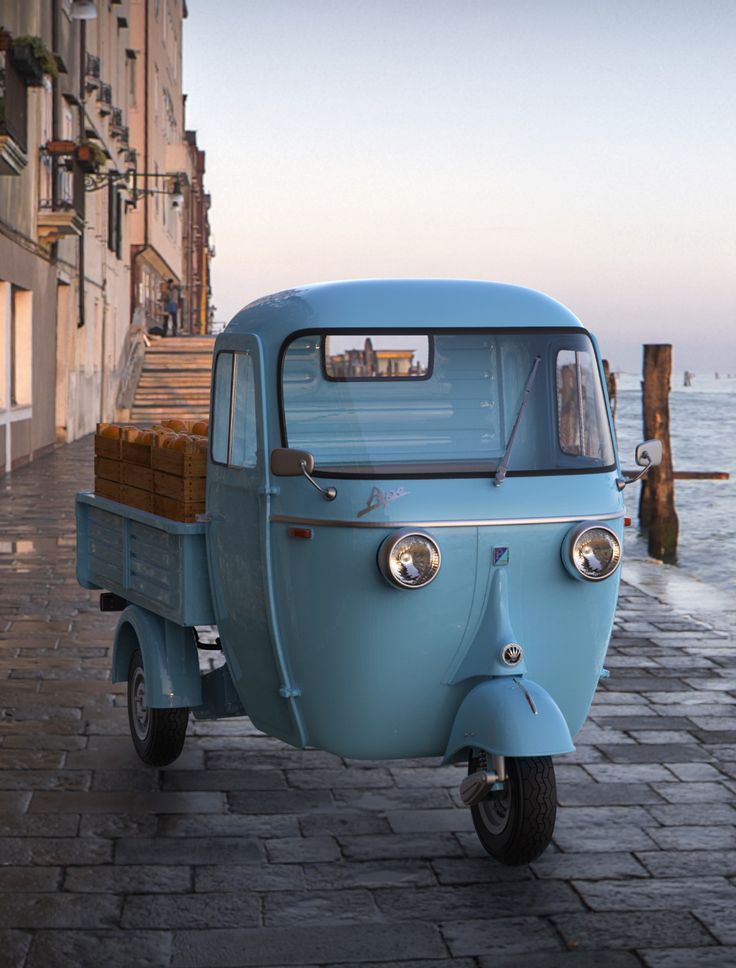 an old blue scooter parked on the side of a street next to water