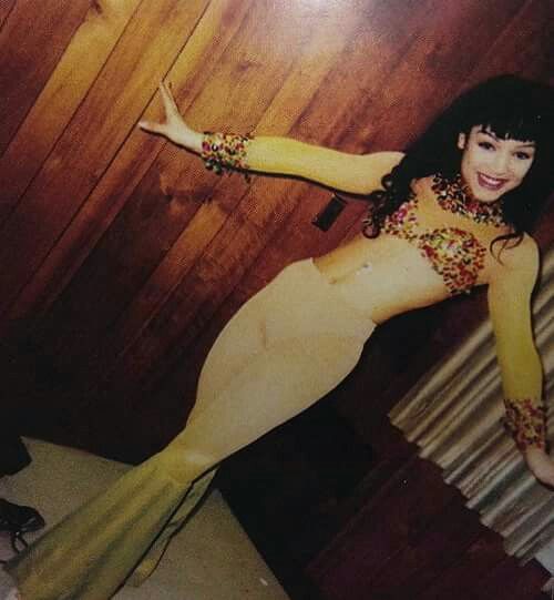 a woman in a yellow dress posing for a photo with her legs spread wide open