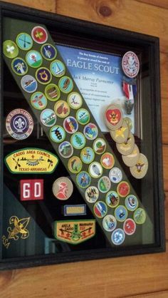 a display case with many different badges on the front and back of it, along with a plaque that reads eagle scout