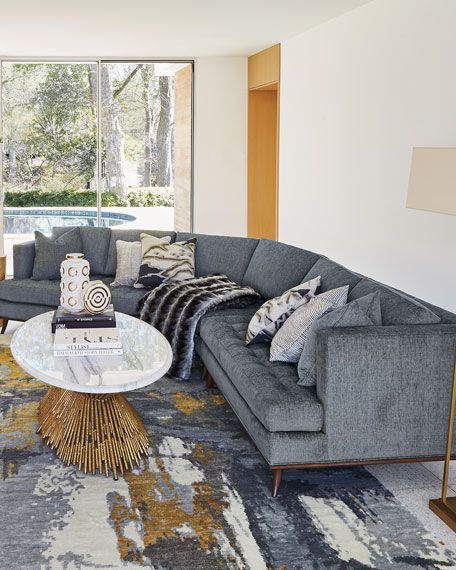 a living room filled with furniture next to a large glass window and a painting on the wall