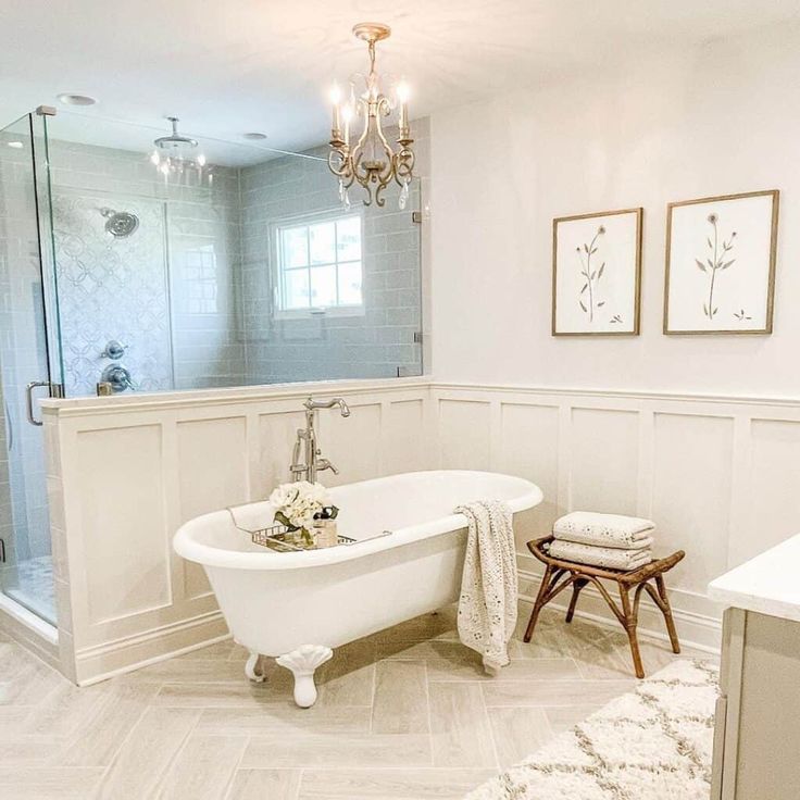 a bathroom with a claw foot tub and chandelier above the bathtub is shown