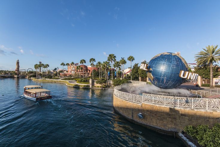 a boat traveling down a river next to a large blue ball