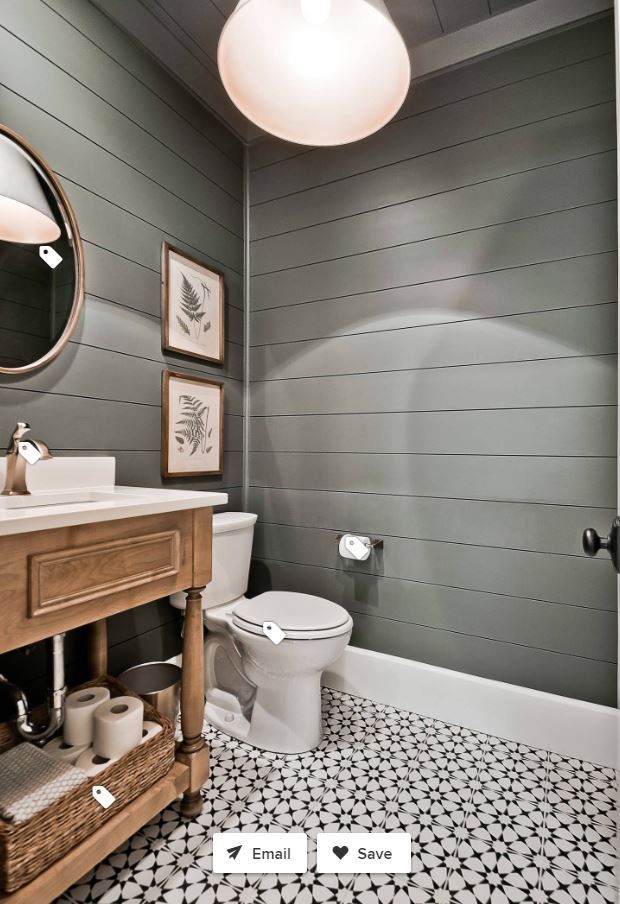 a white toilet sitting next to a sink in a bathroom under a round light fixture