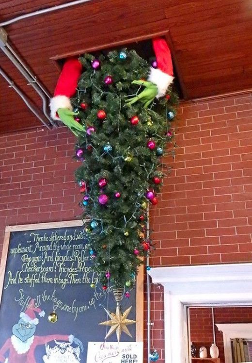 a christmas tree hanging from the ceiling in front of a chalkboard with santa's hat on it