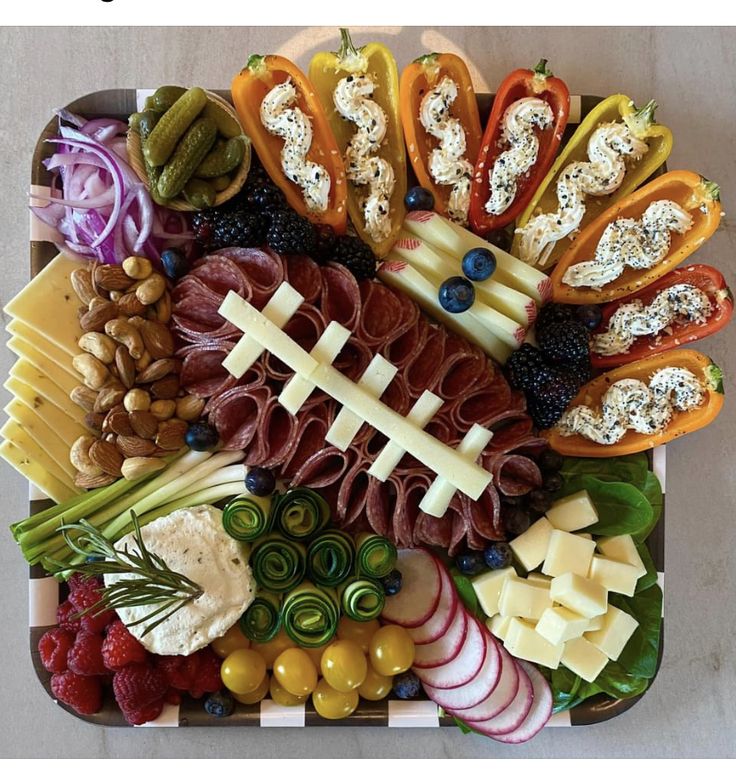 a football shaped platter filled with meats, cheeses, and veggies