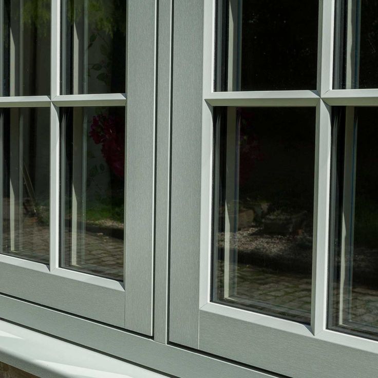 a cat sitting on the ledge of a window sill