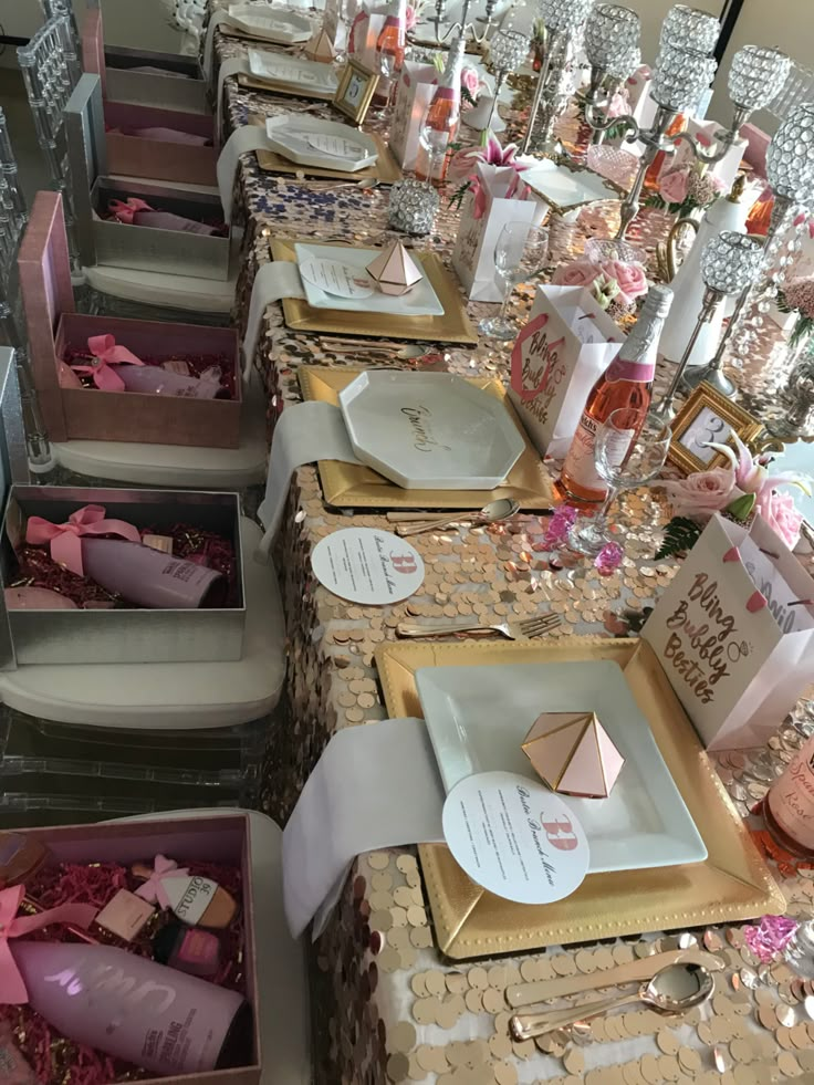 a table set up for a baby shower with pink and gold decorations on the tables