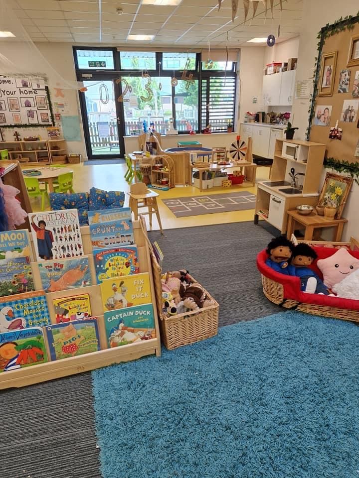 children's books and toys are on display in a classroom setting with blue rugs