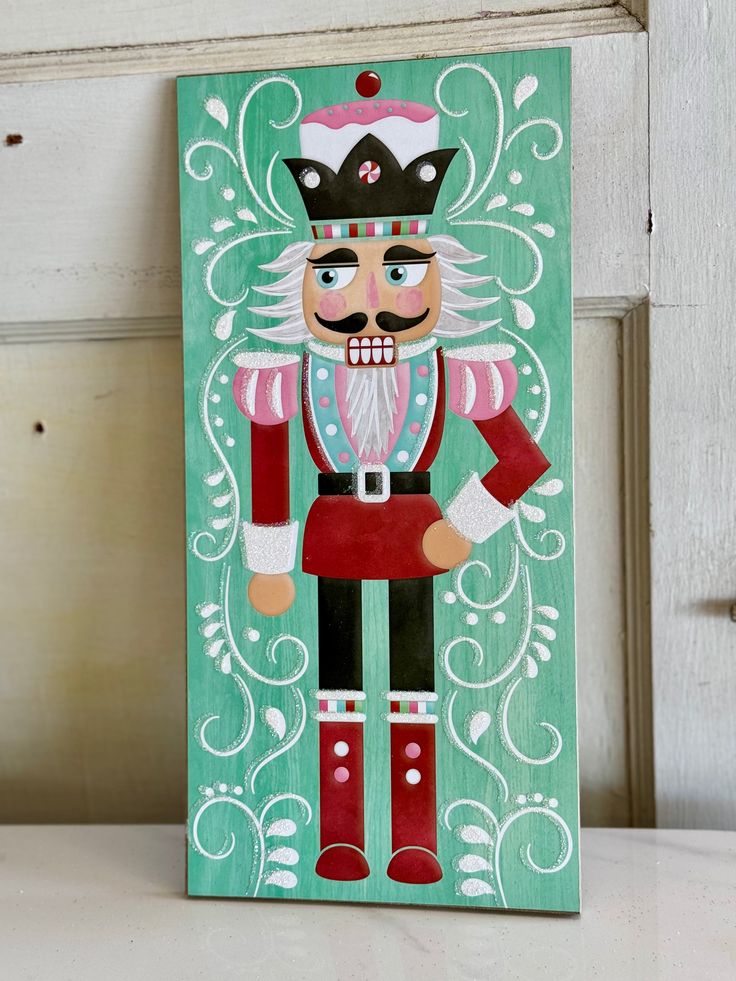 a wooden sign with a nutcracker painted on it