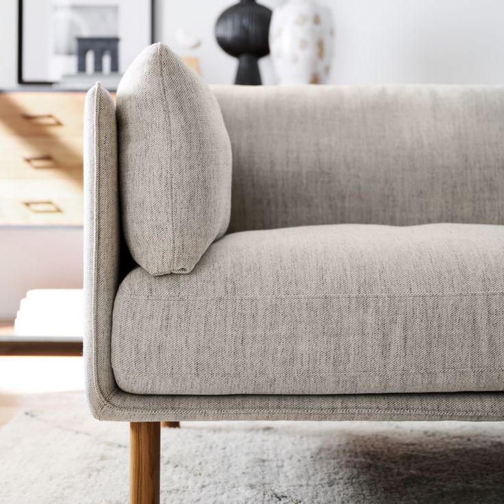 a beige couch sitting on top of a white rug