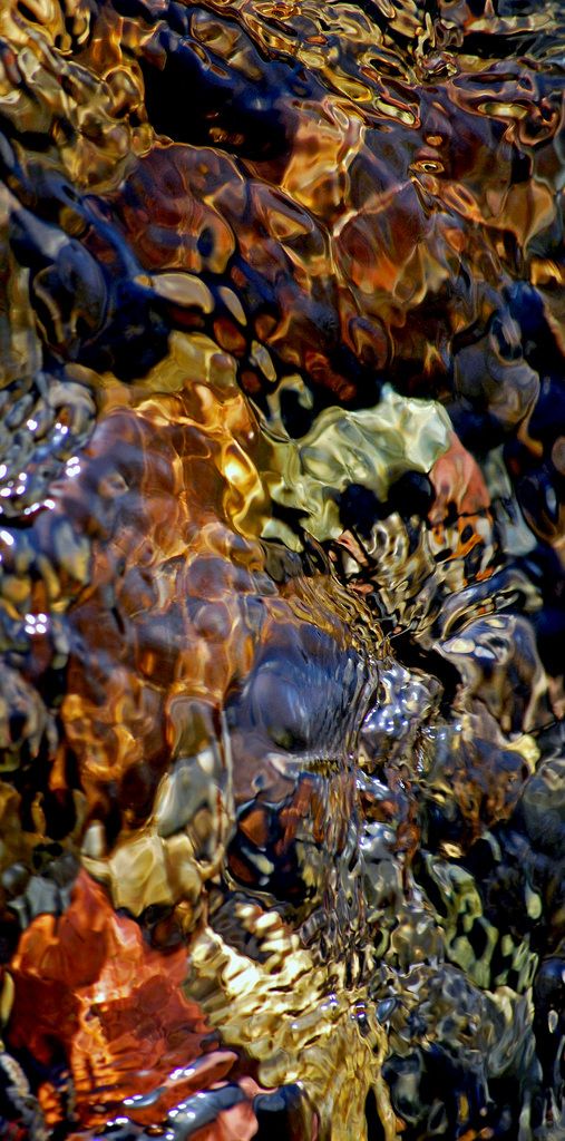 water flowing over rocks and pebbles on the beach