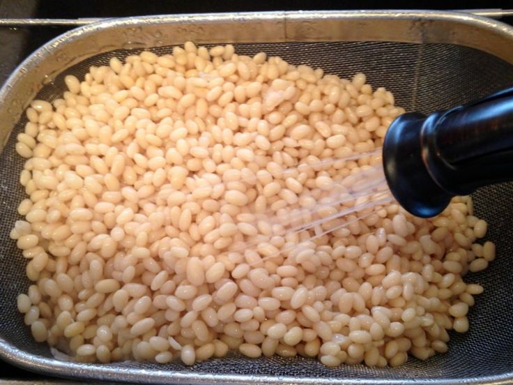 someone is sprinkling rice into a metal pan