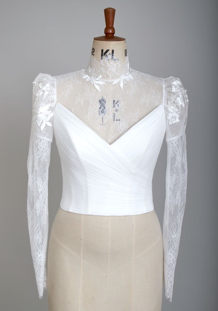 a mannequin with a white dress on it's chest and lace sleeves