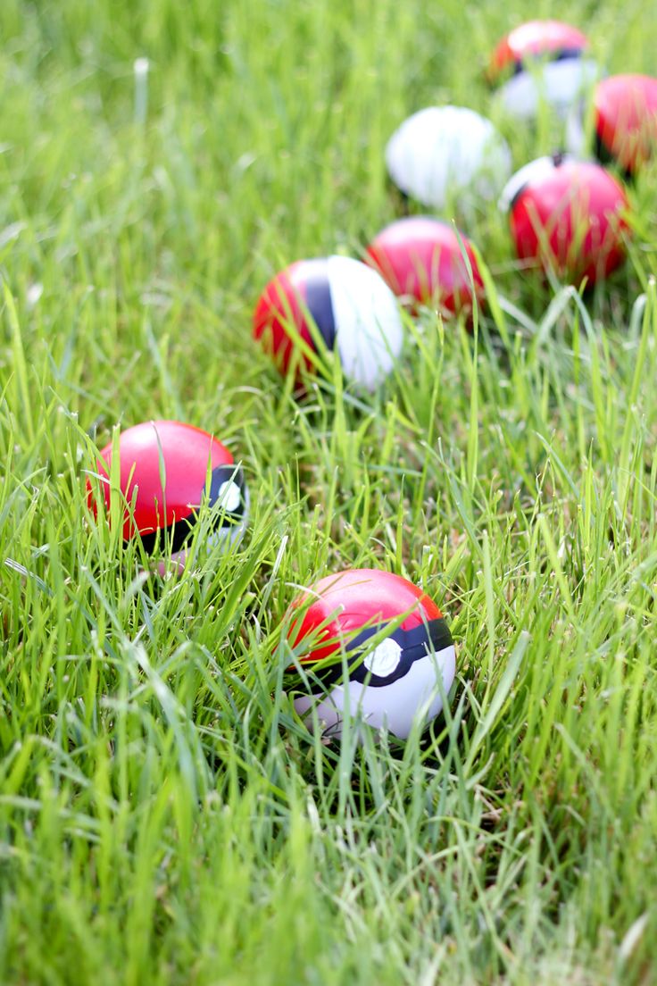 several red and white eggs are in the grass with one egg painted like a ladybug