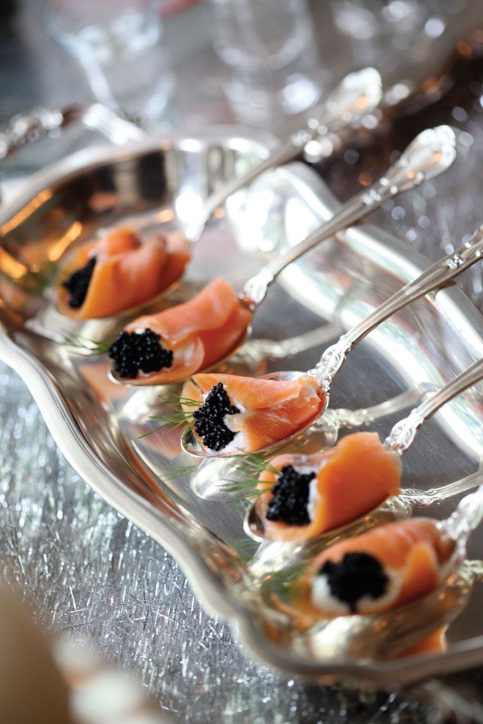 small pieces of salmon with black cavia on a silver platter, ready to be served